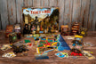 Ticket to Ride Legacy uitgelegd op tafel met doos en spelmateriaal