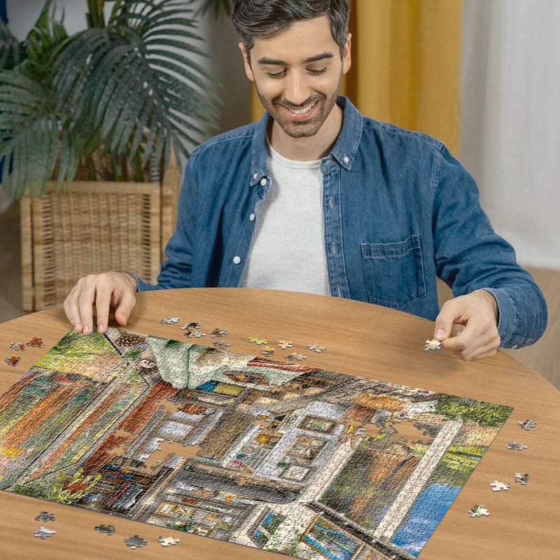 Tiny House in Redwood Forest - Puzzel 1000 stukjes - Ravensburger 12000634, een man is deze puzzel aan het maken
