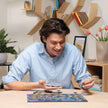 Volwassene legt Ravensburger houten puzzel met natuurthema