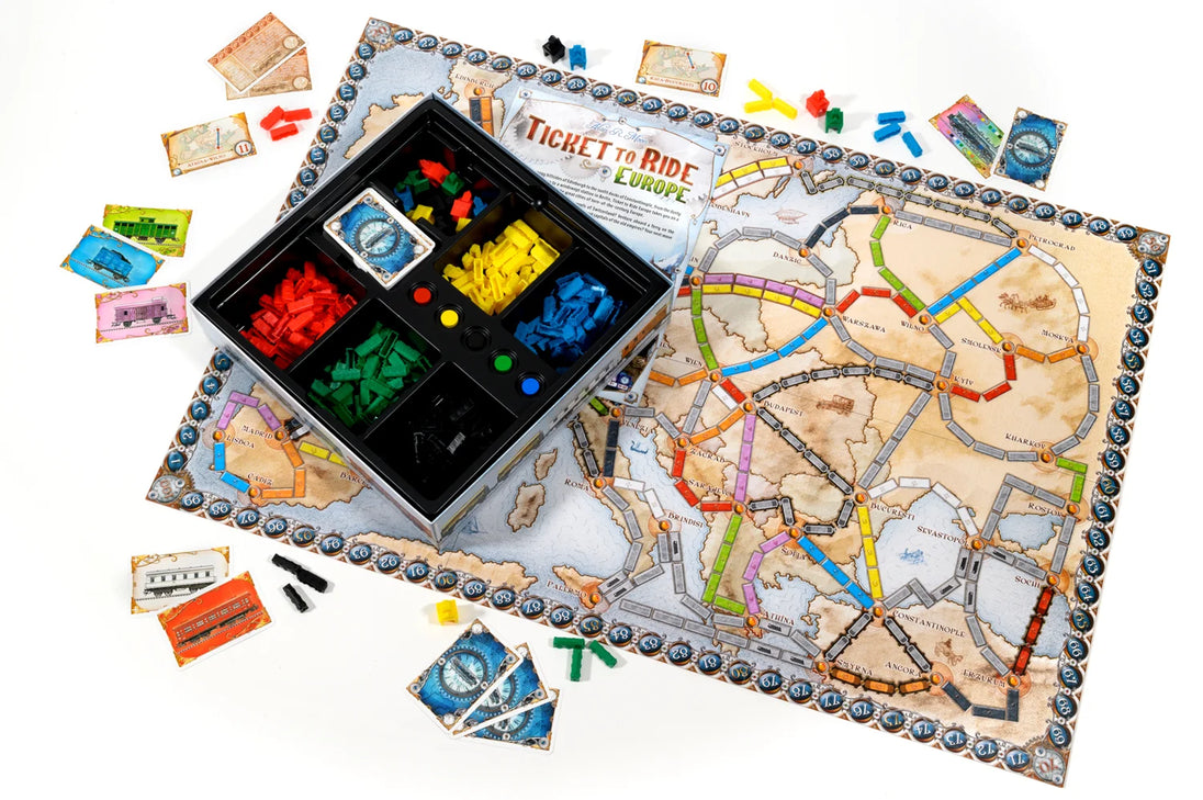 Ticket to Ride Europe spelonderdelen en doos met kleurrijke treinstukken