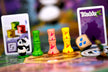 Close-up van drie speelstukken, één dobbelsteen en twee spelkaarten van Takenoko